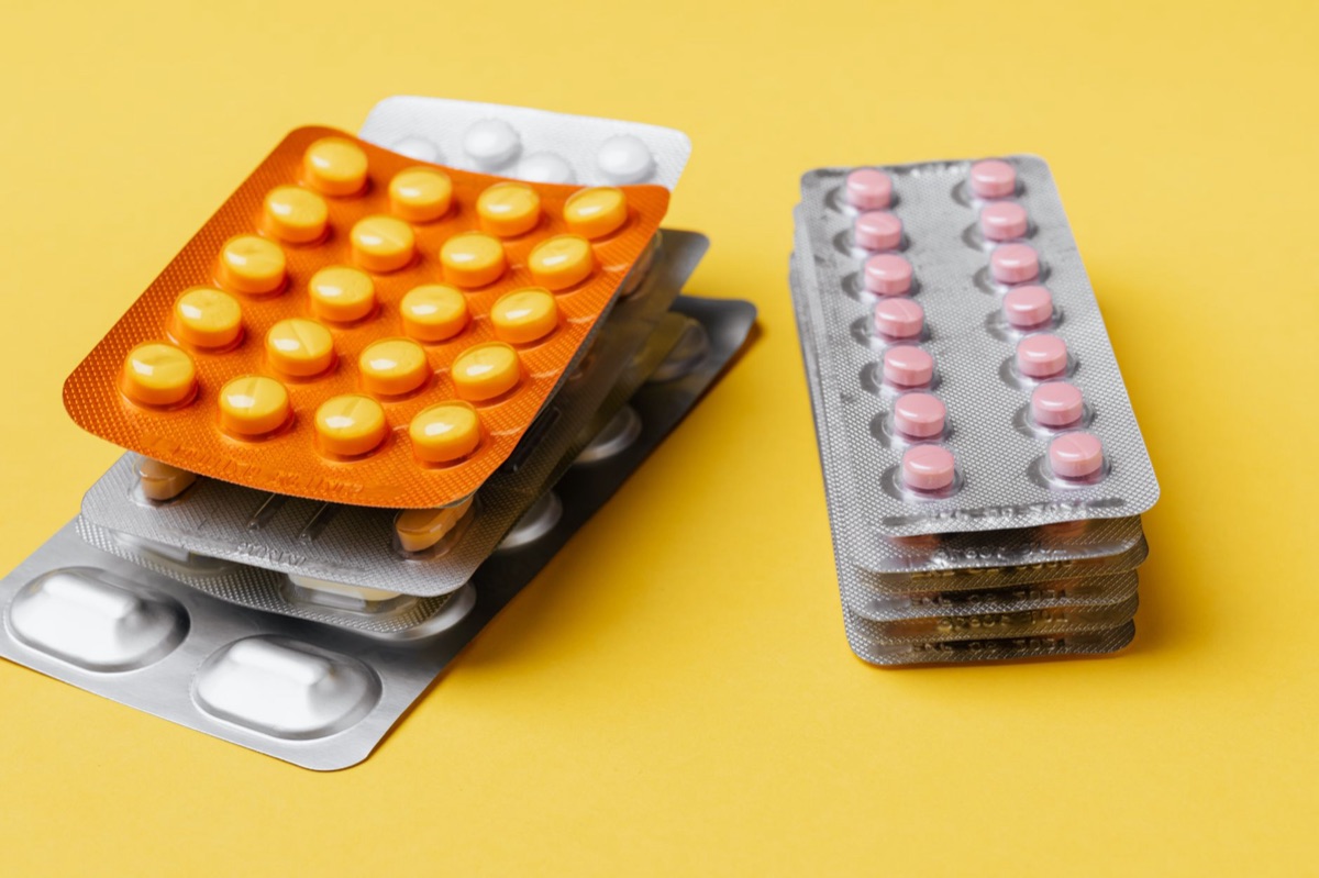 Documentos de seguro médico y pastillas de prescripción médica.