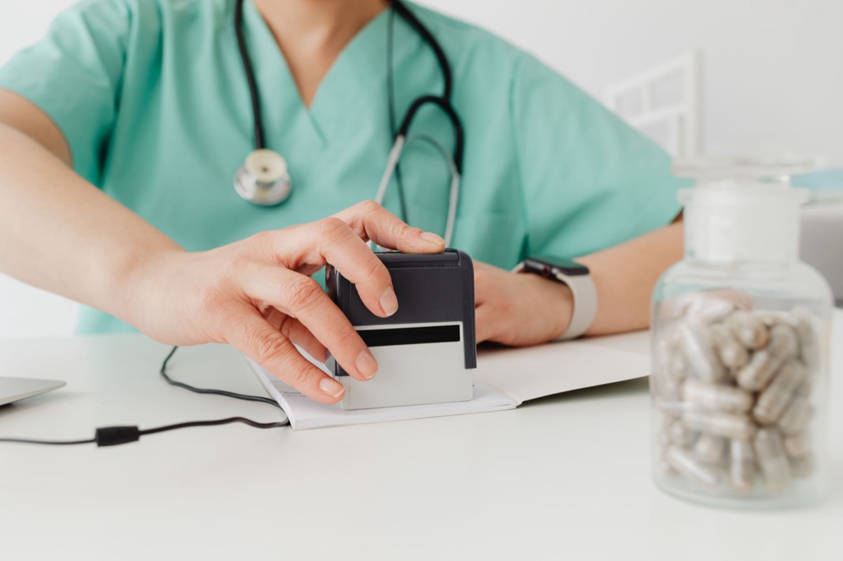 Une carte d'assurance et un flacon de médicaments.